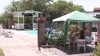 Blonde bimbo licks her friend's nipples and vagina outdoors by pool