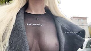 A women shows her tits while walking inside outdoor into the city