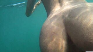 Naked performer swims on a outdoor beach inside Russia.