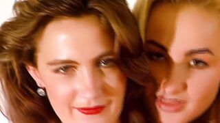 blonde und dark haired kuessen und streicheln sich vor der kamera
