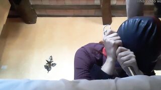 Bound to a machine, masked and hooded, she has to suck a long penis