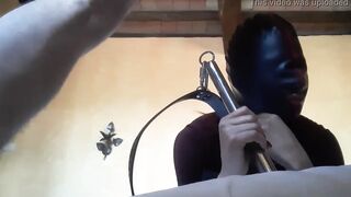 Bound to a machine, masked and hooded, she has to suck a long penis
