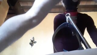Bound to a machine, masked and hooded, she has to suck a long penis