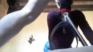 Bound to a machine, masked and hooded, she has to suck a long penis