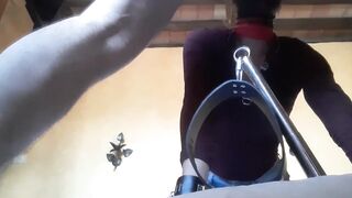 Bound to a machine, masked and hooded, she has to suck a long penis