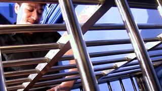 Young man in cage enjoys having large cock up his ass