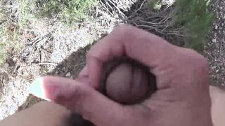 Oriental jock with a pretty face strokes his dick outdoors