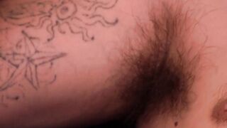 Hairy gay with shaved balls strokes cock while watching porn