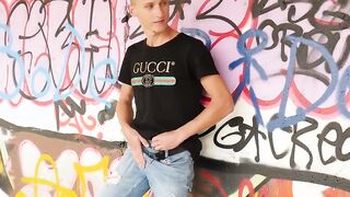 Young guy masturbates in public in front of graffiti wall