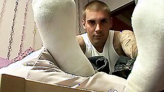 Tattooed guy massages his feet and uses socks on his cock