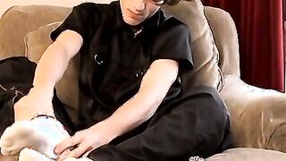 Skinny twink massages his feet and strokes massive dick