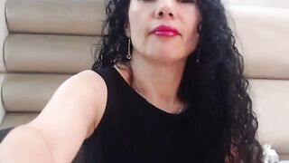 Curly dark haired MILF rubs shaved pussy on webcam