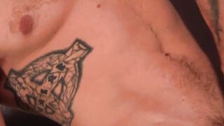 Inked man is stroking his large cock and empties his balls