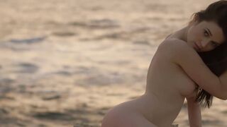 Sensual beauty is showing her naked body while on the beach