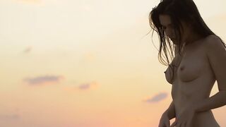 Sensual beauty is showing her naked body while on the beach