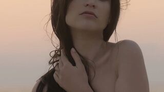 Sensual beauty is showing her naked body while on the beach