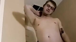 Cute amateur Jack with glasses masturbates on a leather sofa