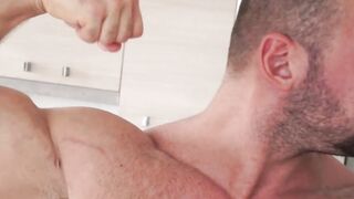 Muscular gay hunk playing with his big curved cock