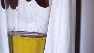 Adorable Japanese chick sits on the toilet and pees in a cup