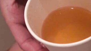 Japanese cutie fills a cup up with her pee and records it