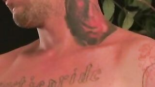 Tattooed dude tugging on his cock until he cums on his belly