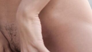 The gorgeous brunette who has a slim body gently strokes it