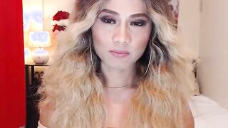 Asain blonde TS wanks cock in chair in front of webcam