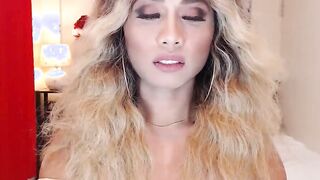 Asain blonde TS wanks cock in chair in front of webcam