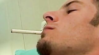 Mike Roberts blows a cloud of smoke while rubbing his cock
