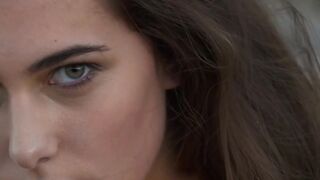 On a beach a barechested Katrine Pirs performs her stripping