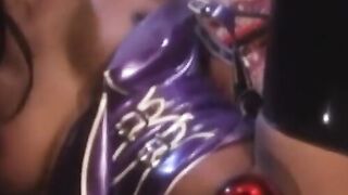 A curvaceous latex vixen dominates a young darkskinned beauty