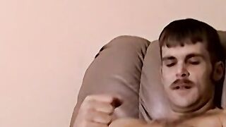 Moustached guy jerks off in his comfy couch