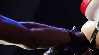 The accessories are black, black boots, a black jockstrap, and black-gloved hands dem