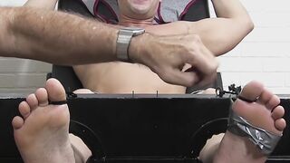 Restrained hunk laughs while tickle tormented by his dom