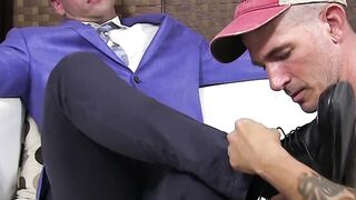 Dominant man strokes his penis while a dude licks his feet