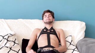 Teen twink Malachi Cooper enjoys wanking his huge cock on the couch