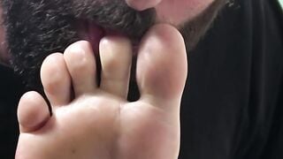 Bearded dude is licking his muscular friends toes and feet