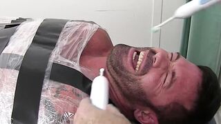 Restrained hunk endures tickling torment from his dom