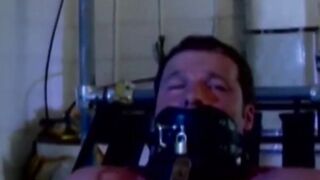 MuscleJockBound.com - Muscular man silenced with a ball gag while being heavily chain