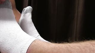 Hunk jerks his dick off while another man licks his feet