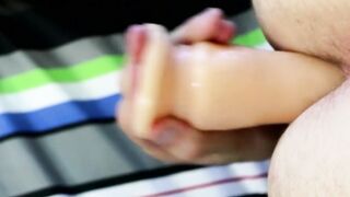 Twink tugs on his massive cock and uses dildo on his ass