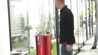 Busty beauty seduces two behind the glass