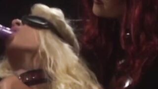 "Redheaded Dominatrix Uses Mega Dildo to Discipline Submissive Lesbians"