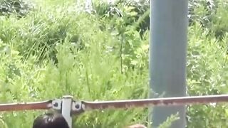 Two uniformed schoolgirls relieve themselves in the grass