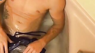 Muscular jock playing with cock during steamy bath