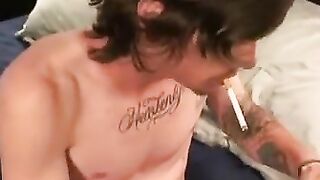 Tattooed dude smokes cigars while stroking gently