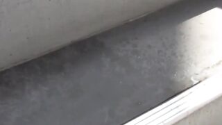 Young woman scans rooftop seeking spot for full bladder dump