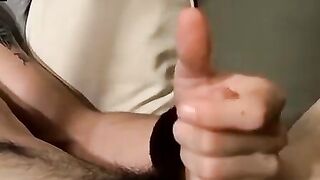 Guitar player strums while stroking hairy cock