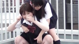 On quiet rooftop pair of student teens share joint pee break