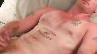 Tattooed hunk flexes muscles before jerking his meat